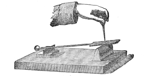 The heated rocker being laid on its block of lead. Rocking on the hot metal, it taps fast enough for the taps to run together into a deep musical note, which rises in pitch as the rocker is pressed down with the point of a file.