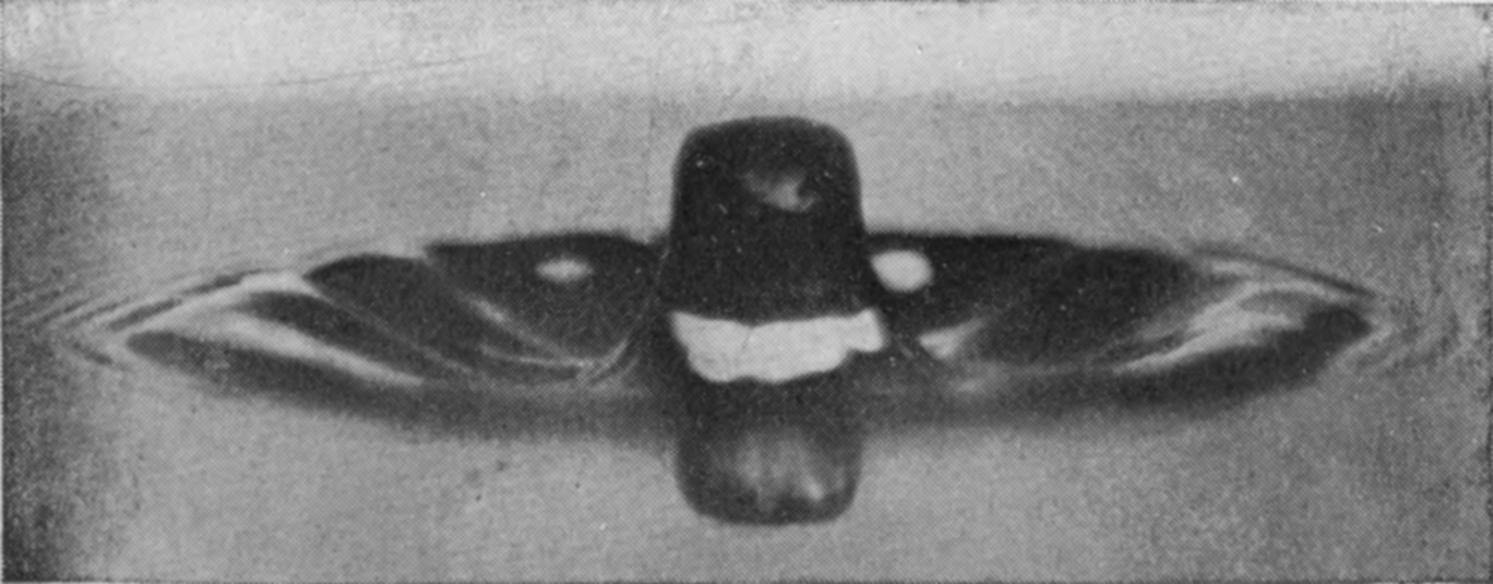 8 0·073 sec. — The central column, rounded at the top, stands in a dark sheet of liquid ringed by many fine concentric ripples.