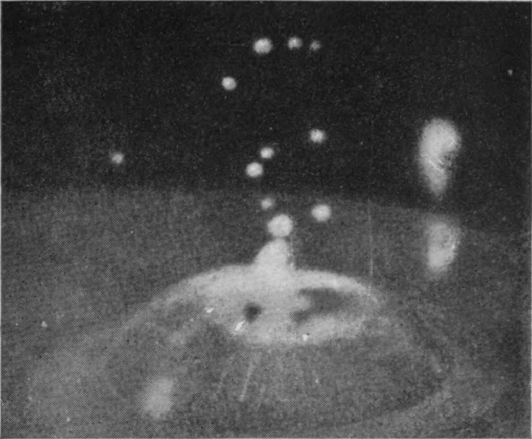 9 0·085 sec. — The bubble has reopened and settled into a broad low dome with a short peak at its summit and drops thrown high above; the column is dimly seen through its walls.