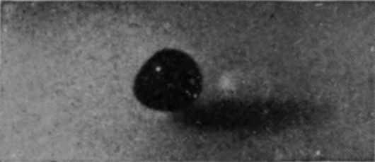 1 T = 0 — The large water-drop is seen as a dark ball at the milky surface, with its shadow lying on the liquid beside it.