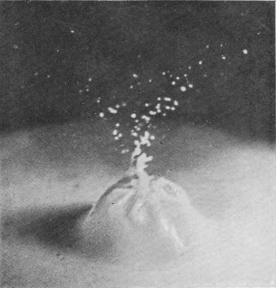 6 0·020 sec. — The bubble has closed into a rough, furrowed, pointed dome with a twisted spout of liquid at its summit and spray scattered above.