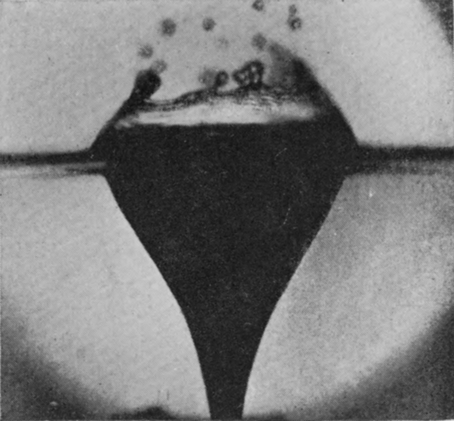 1 0·055 sec. — Viewed through the side of the vessel, a deep funnel of air hangs below the surface while the top of the burst bubble breaks into drops above.