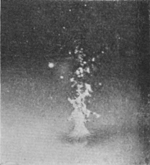 6 0·004 sec. — A ragged column, crowned with droplets, rises from the still very flat surface where the converging streams have met.