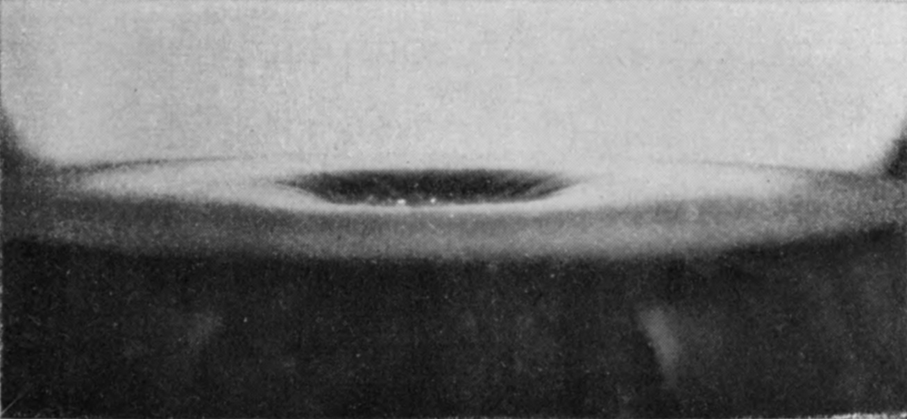 3 — The sphere has nearly disappeared, leaving a wide shallow saucer in the glycerine with a dark hollow at its centre.