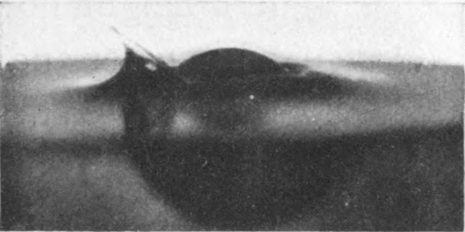3 0·002 sec. — A single jet has escaped on the left and rises as a thin blade beside the sinking sphere.