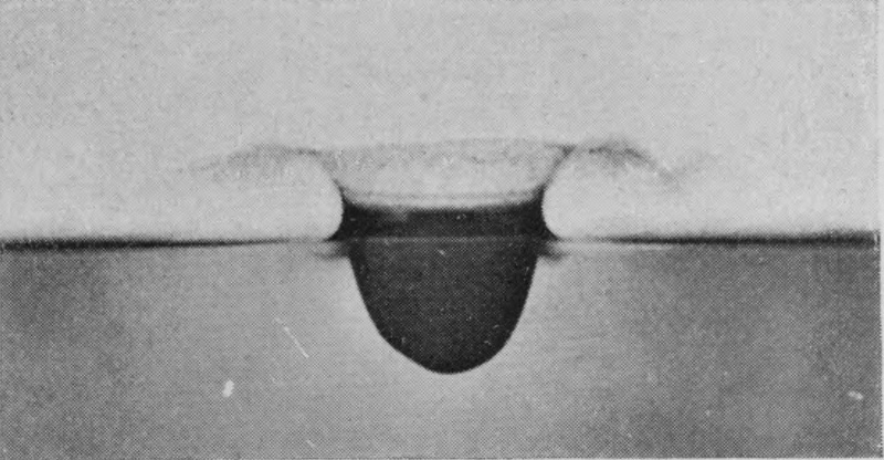 1 T = 0 — A low, wide-brimmed crater has risen above the surface, with a short, rounded cavity below it.