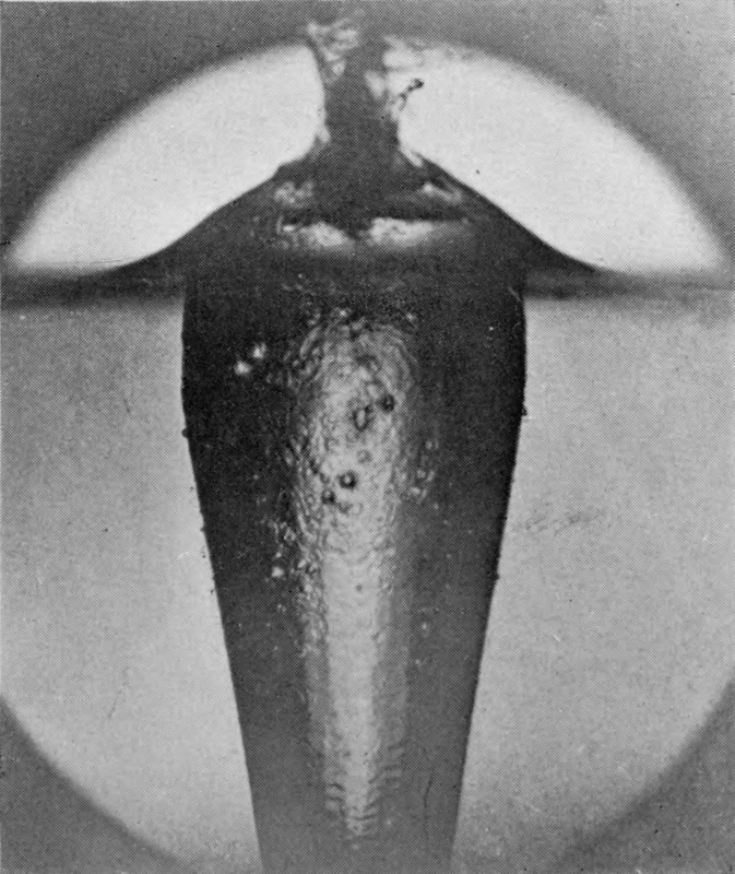4 — The crater has closed into a narrow neck with a splash spouting above it, and at the top of the air-column below there is much internal splashing and a cloud of bubbles.